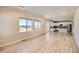 Open-concept living room with natural light, wood floors, and seamless flow to a modern kitchen at 6646 Merrimack Dr, Castle Pines, CO 80108