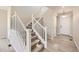 Bright foyer with a staircase featuring white wood railing and light wood-style flooring at 6646 Merrimack Dr, Castle Pines, CO 80108