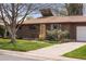 Charming brick home with mature landscaping, a well-kept lawn, and a quaint front entrance at 4182 W Quinn Pl, Denver, CO 80236