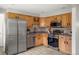 Well-equipped kitchen featuring stainless steel appliances, light wood cabinets, and tile flooring at 4182 W Quinn Pl, Denver, CO 80236