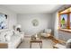 Cozy living room with a bay window, a comfortable sofa, and a decorative mirror at 4182 W Quinn Pl, Denver, CO 80236