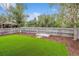 Fenced backyard showcasing an artificial lawn, a sandbox, and mature trees for added privacy and shade at 21052 E 45Th Ave, Denver, CO 80249