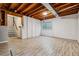 Unfinished basement with exposed wood beams, plank flooring and a small window at 21052 E 45Th Ave, Denver, CO 80249