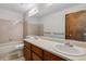 Bright bathroom with a dual-sink vanity, a large mirror, and a tiled bathtub and shower combination at 21052 E 45Th Ave, Denver, CO 80249