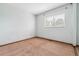 A bright, carpeted bedroom with a window bringing in natural light, creating a cozy and inviting space at 21052 E 45Th Ave, Denver, CO 80249