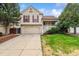 Two-story home featuring a well-kept lawn, an attached two-car garage, and mature landscaping at 21052 E 45Th Ave, Denver, CO 80249