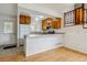 Bright kitchen featuring wooden cabinets, tile countertops, breakfast bar, and stainless steel appliances at 21052 E 45Th Ave, Denver, CO 80249