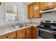 Well-lit kitchen featuring wooden cabinets, stainless steel appliances, and a double basin sink under a window at 21052 E 45Th Ave, Denver, CO 80249