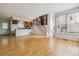 Open-concept living space with breakfast bar, wood floors, staircase, and abundant natural light at 21052 E 45Th Ave, Denver, CO 80249