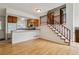 Open-concept living space with breakfast bar, wood floors, staircase, and abundant natural light at 21052 E 45Th Ave, Denver, CO 80249