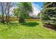 Large, grassy backyard featuring mature trees and a well-maintained wooden fence at 1173 Xenon St, Golden, CO 80401