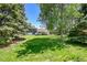Spacious backyard with mature trees and a covered patio area, perfect for outdoor living at 1173 Xenon St, Golden, CO 80401