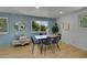 Modern dining area with a wood table, stylish chairs, and a light blue accent wall at 1173 Xenon St, Golden, CO 80401