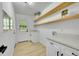 Well-lit laundry room with white cabinets, floating shelves, and modern fixtures at 1173 Xenon St, Golden, CO 80401