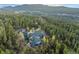 Aerial view of the estate nestled among lush evergreen trees and landscape at 11406 Conifer Ridge Dr, Conifer, CO 80433