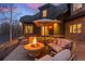Inviting back patio with a stone fire pit, comfortable seating, and an umbrella for shade at 11406 Conifer Ridge Dr, Conifer, CO 80433