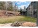 Well-maintained backyard with stone accents, landscaping, mature trees, and a lush green lawn at 11406 Conifer Ridge Dr, Conifer, CO 80433