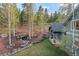Landscaped backyard with a rock-lined stream, mature trees, and lush lawn at 11406 Conifer Ridge Dr, Conifer, CO 80433
