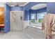 Bathroom with a tiled shower, soaking tub with nature views, and blue accent wall at 11406 Conifer Ridge Dr, Conifer, CO 80433