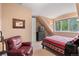 Bedroom featuring a comfortable leather chair, natural light, and southwestern-patterned bedding at 11406 Conifer Ridge Dr, Conifer, CO 80433