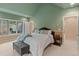 A spacious bedroom with natural light, featuring a vaulted ceiling, large windows, and a cozy sitting area at 11406 Conifer Ridge Dr, Conifer, CO 80433