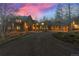 Stunning exterior with stone and stucco, elegant lighting, and a circular driveway leading to the garages at 11406 Conifer Ridge Dr, Conifer, CO 80433