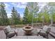 Outdoor fire pit area surrounded by mature trees, seating, and mountain views at 11406 Conifer Ridge Dr, Conifer, CO 80433