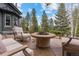 Outdoor fire pit area with comfortable seating and views of the surrounding trees and sky at 11406 Conifer Ridge Dr, Conifer, CO 80433