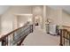 Hallway with carpet floors, iron railing, and views through doorways to other rooms at 11406 Conifer Ridge Dr, Conifer, CO 80433