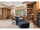 Cozy living room with built-in bookshelves, comfortable seating, and view of wooded landscape at 11406 Conifer Ridge Dr, Conifer, CO 80433