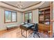 Bright office with built-in shelves, wood floors, and large windows with wooded views at 11406 Conifer Ridge Dr, Conifer, CO 80433