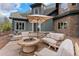 Outdoor patio with a fire pit, comfortable seating, and lush green landscaping at 11406 Conifer Ridge Dr, Conifer, CO 80433