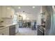 Modern kitchen with white cabinets, stainless steel appliances, and a view into a separate living area, enhancing the home's open feel at 13833 W 68Th Ave, Arvada, CO 80004