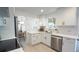 Well-lit kitchen featuring white cabinets, stainless steel appliances, and an open layout leading to the dining area at 13833 W 68Th Ave, Arvada, CO 80004