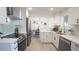 Updated kitchen with white cabinets, stainless steel appliances, and a view into the adjacent dining area at 13833 W 68Th Ave, Arvada, CO 80004