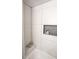 Modern shower with white tile, a convenient niche, and a built-in bench at 13833 W 68Th Ave, Arvada, CO 80004