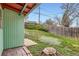 A view of the backyard featuring a wooden fence, green lawn, and partial shade from mature trees at 7948 Stuart St, Westminster, CO 80030