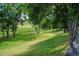 Scenic common area featuring lush green grass, mature trees, and a natural creek bed at 381 S Ames St # F208, Lakewood, CO 80226