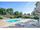 Community swimming pool with sun loungers, gazebo, and lush landscaping in a fenced area at 381 S Ames St # F208, Lakewood, CO 80226