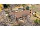 Aerial view of a home with mature trees, a stone chimney, and a backyard at 6980 Oak St, Arvada, CO 80004