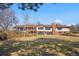 Backyard view of the brick home featuring a balcony and mature trees at 6980 Oak St, Arvada, CO 80004