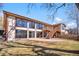 Backyard view of the home, showcasing many large windows and backyard deck at 6980 Oak St, Arvada, CO 80004