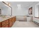 Bathroom with marble floors, dual sinks, a soaking tub, and a skylight at 6980 Oak St, Arvada, CO 80004