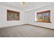 Neutral bedroom with carpet and natural light from dual windows; wood trim at 6980 Oak St, Arvada, CO 80004