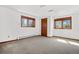 An empty bedroom with carpeting, white walls and three light-filled windows at 6980 Oak St, Arvada, CO 80004