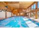 Indoor pool and hot tub with vaulted ceilings and wood paneling at 6980 Oak St, Arvada, CO 80004