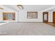 Bright living room with large windows offering outdoor views and a door leading to an indoor pool at 6980 Oak St, Arvada, CO 80004