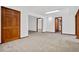 Open living room with neutral carpet and wood doors, and trim throughout at 6980 Oak St, Arvada, CO 80004