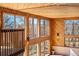 Bright sun room with wood paneled walls and ceiling with many windows at 6980 Oak St, Arvada, CO 80004