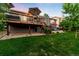 Well-maintained backyard with a large deck, a patio with outdoor seating, and manicured lawn at 1758 Parkdale N Cir, Erie, CO 80516